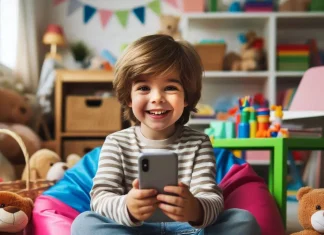 Niño rodeado de juguetes con un teléfono en sus manos