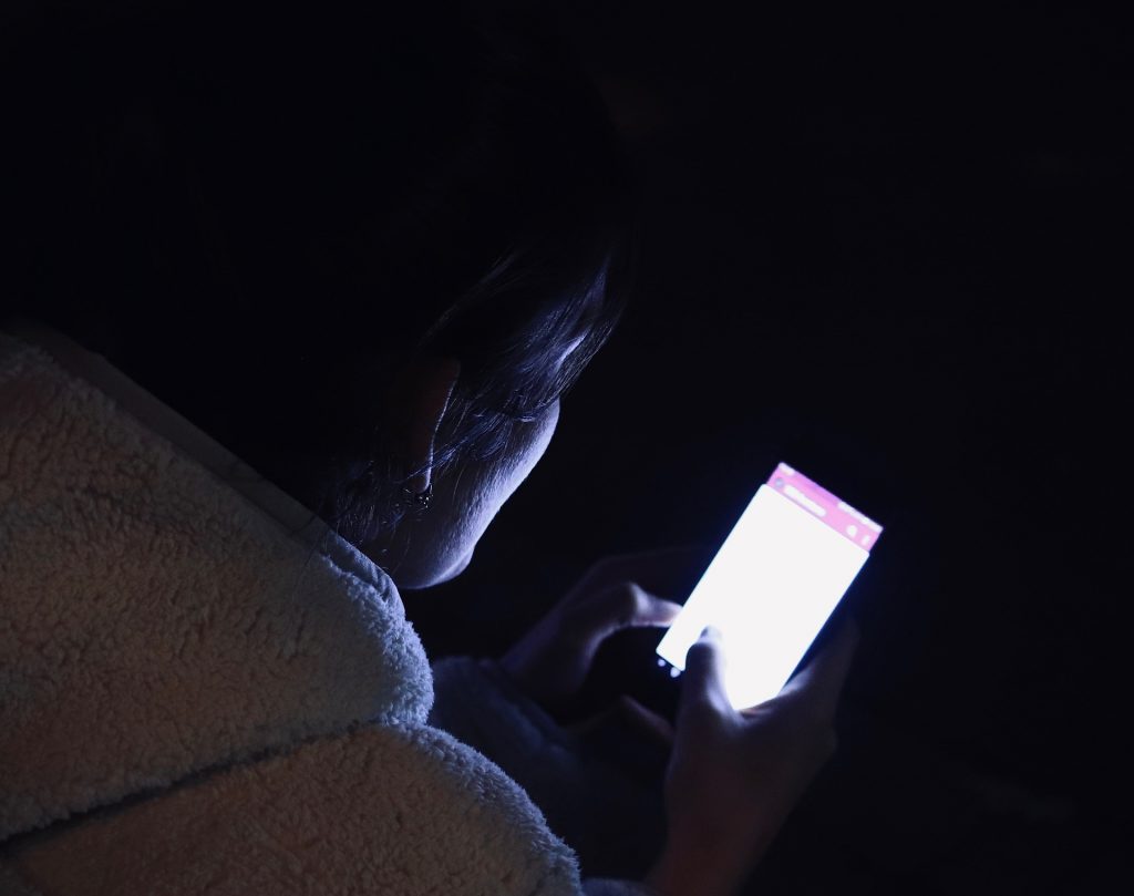 Adolescente utilizando el móvil por la noche. Uso responsable de pantallas