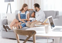 Padre y madres hablando distendidamente con su hijo en el salón de su casa