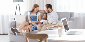 Padre y madres hablando distendidamente con su hijo en el salón de su casa