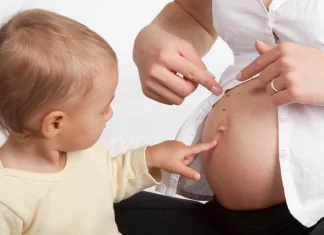 Madre contando a su hijo que está esperando a un hermanito